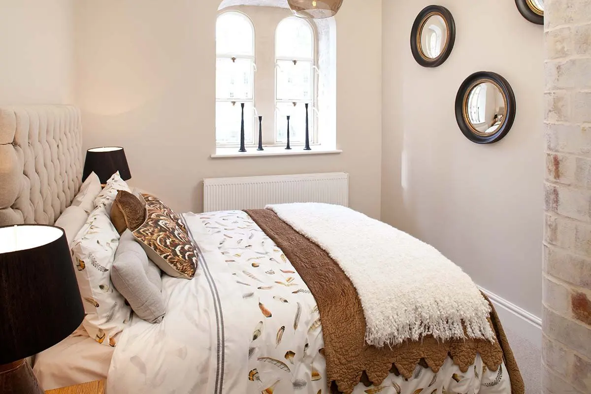 Bedroom with an arched window and round mirrors