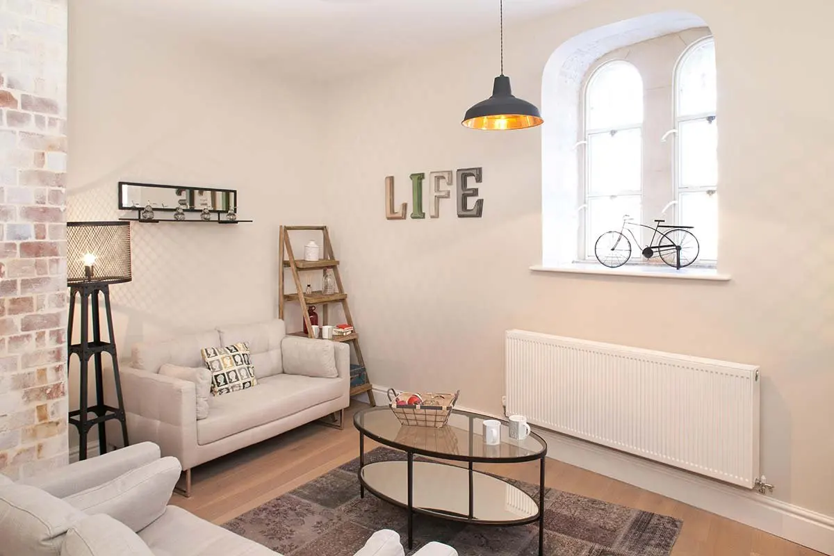 Living room with a 'Life' sign and a bicycle on the wall