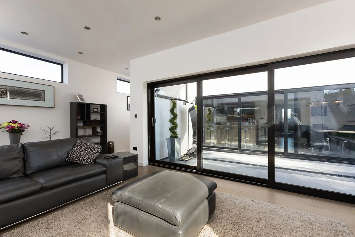 Living room opening onto a garden through wide glazed doors