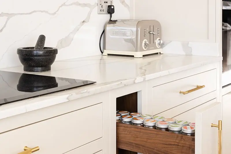 Hob beside an open drawer of herb and spice jars
