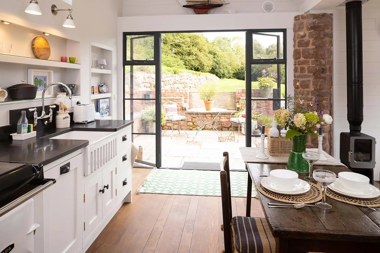 Cabin kitchen with French doors open onto a garden