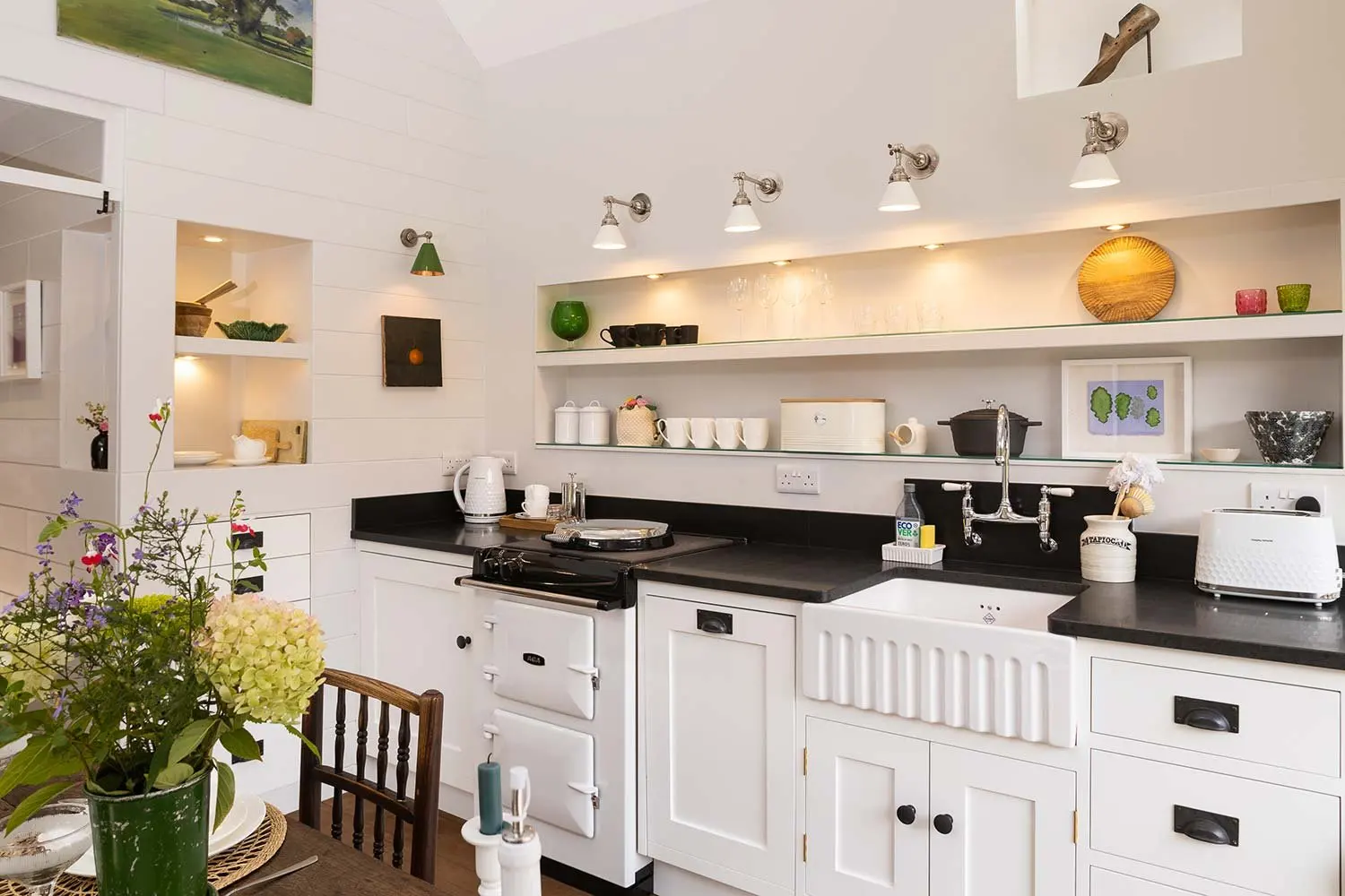 White kitchen with open shelves and a black worktop