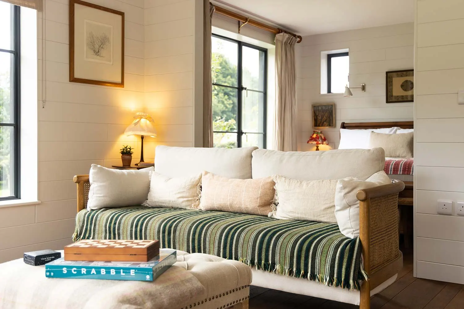 Striped day bed with a board game on the ottoman