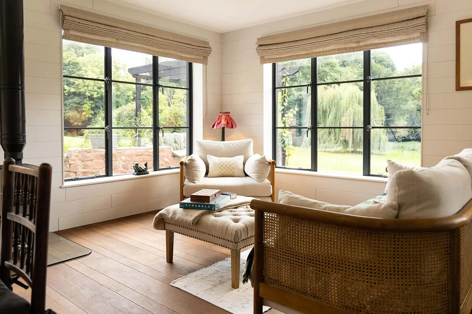 Living area with steel-framed windows looking out over fields