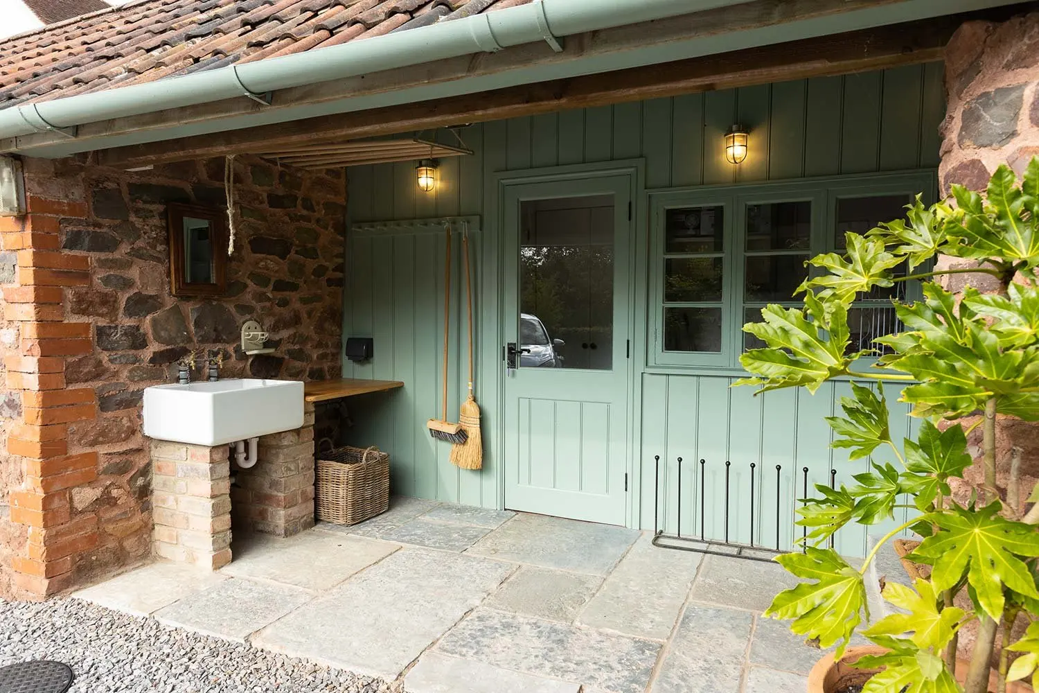 Covered porch with a sink and climbing plants