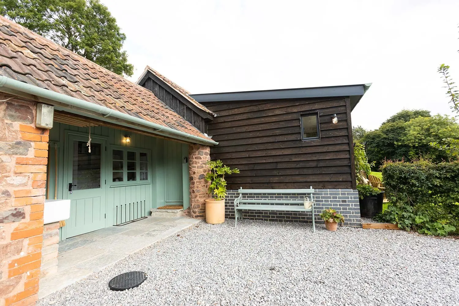The cabin’s sage-green doors and gravel drive
