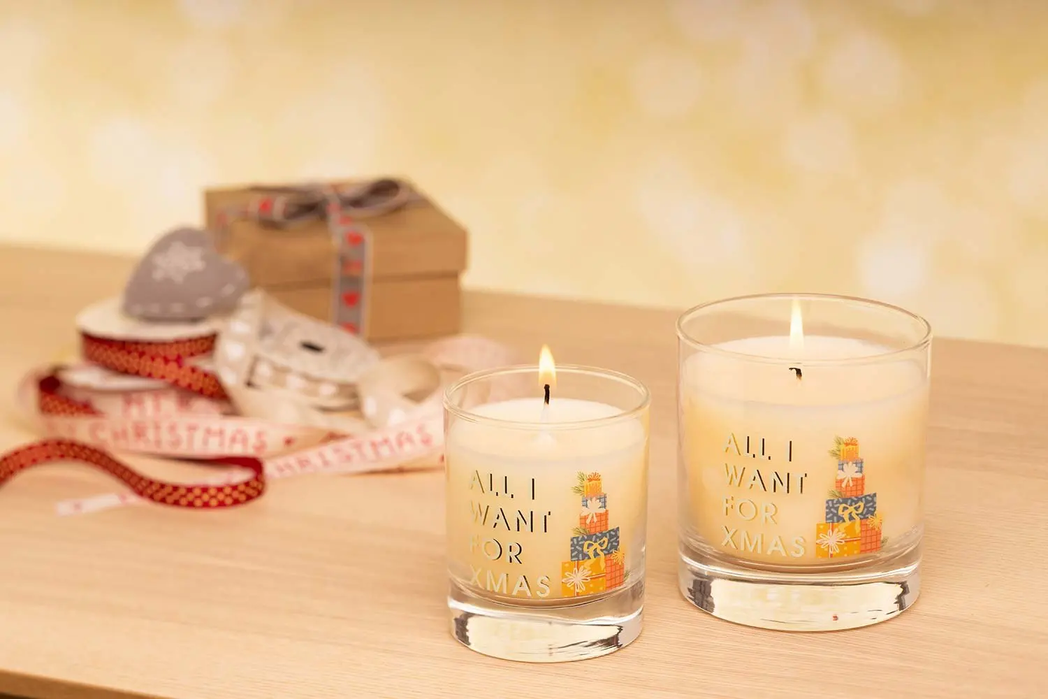 Lit Christmas candles with ribbon and gift boxes