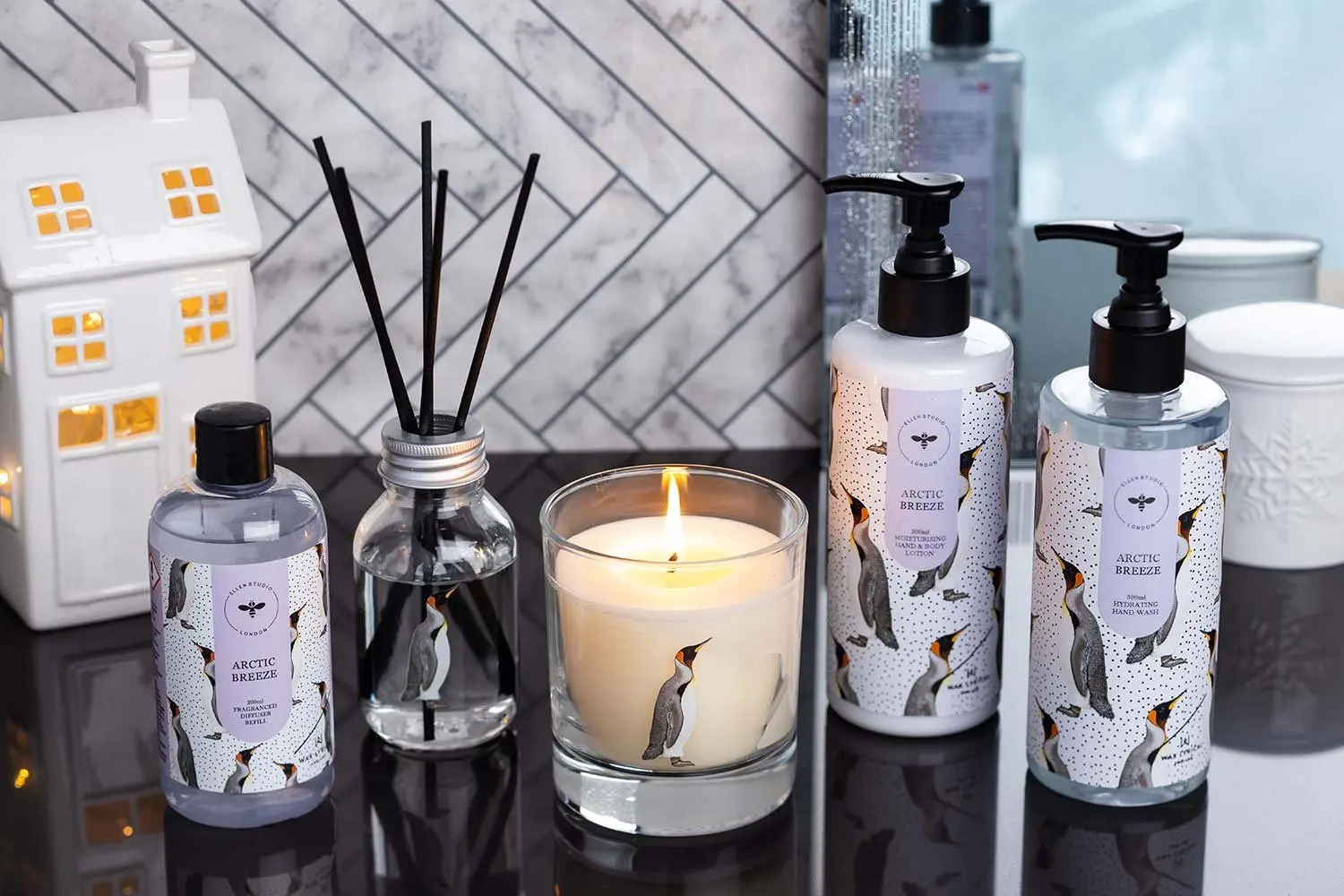 A candle, soap and diffuser collection with a house ornament