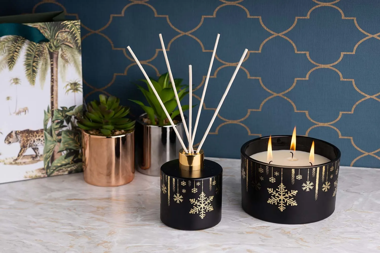 Candles and a reed diffuser in a styled festive scene
